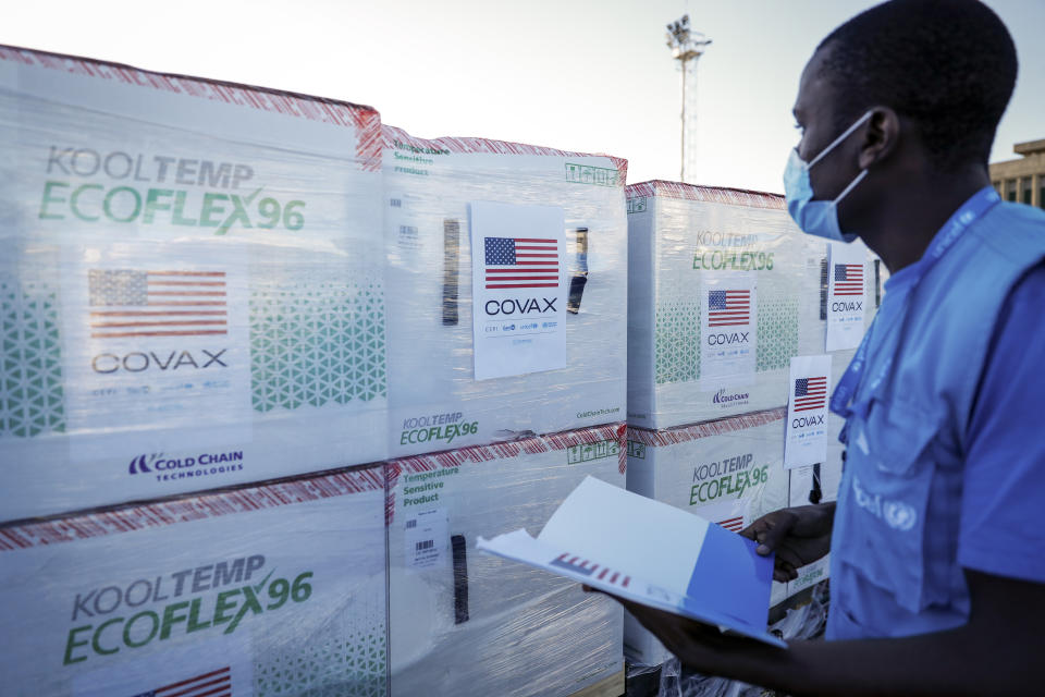 FILE - A UNICEF worker checks boxes of the Moderna coronavirus vaccine after their arrival at the airport in Nairobi, Kenya, Aug. 23, 2021. The emergence of the new omicron variant and the world's desperate and likely futile attempts to keep it at bay are reminders of what scientists have warned for months: The coronavirus will thrive as long as vast parts of the world lack vaccines. COVAX was supposed to avoid such inequality. (AP Photo/Brian Inganga, File)