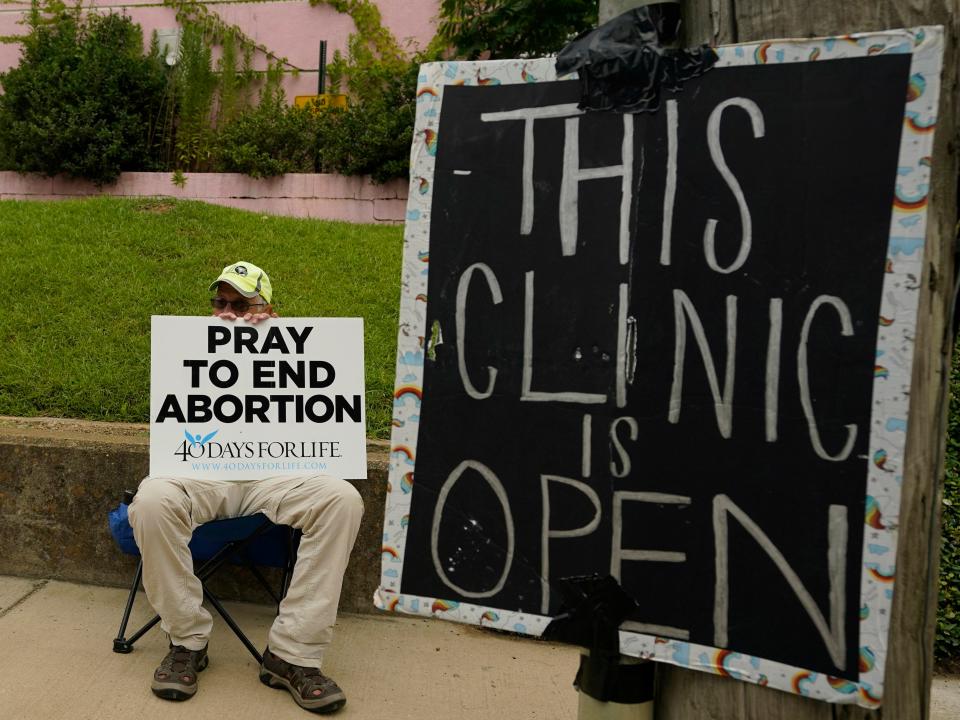 A protestor with a sign that says "Pray to end abortion."