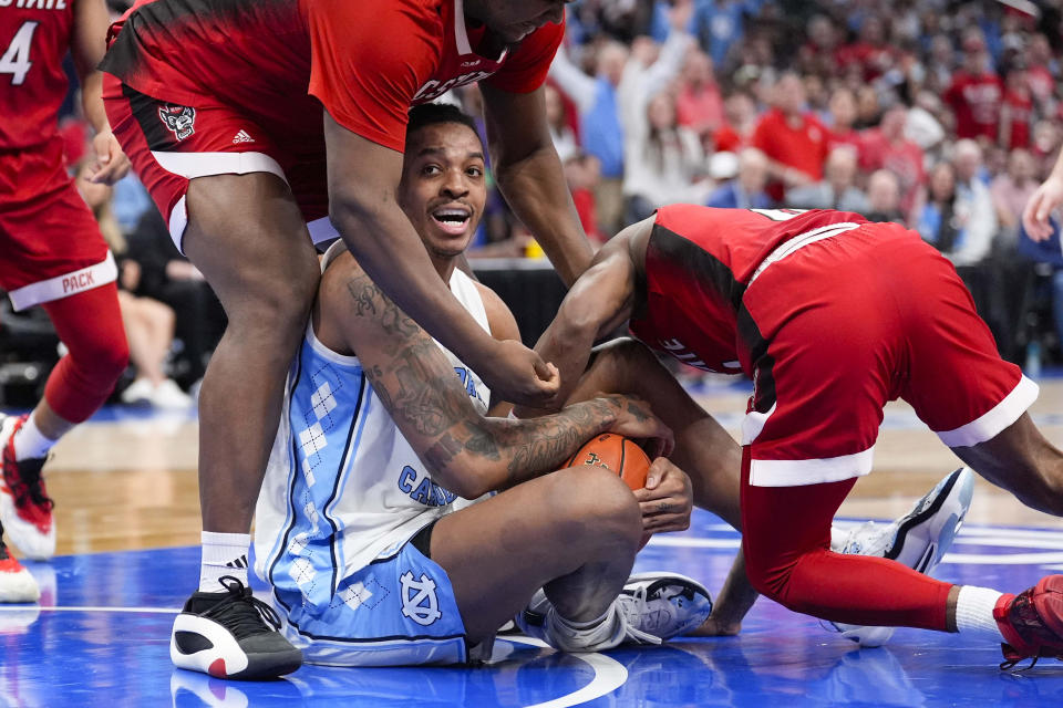 North Carolina forward Armando Bacot (5) fights for the ball against North Carolina State forward DJ Burns Jr. (30) and North Carolina State guard DJ Horne (0) during the second half of an NCAA college basketball game in the championship of the Atlantic Coast Conference tournament, Saturday, March 16, 2024, in Washington. (AP Photo/Alex Brandon)
