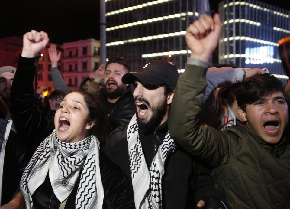 Anti-government protesters shout slogans, as they block a main road during ongoing protests against the ruling elite of corruption and financial crisis, in Beirut, Lebanon, Monday, Jan. 13, 2020. Lebanon is facing its worst economic crisis in decades, while protests against corruption and mismanagement have gripped the country since October. (AP Photo/Hussein Malla)