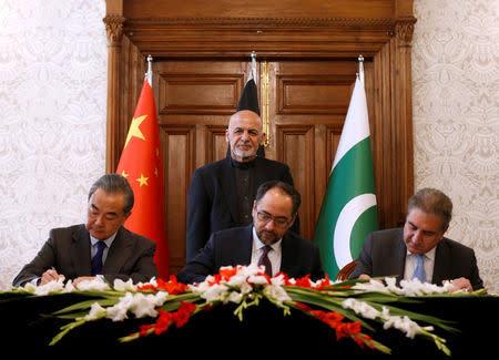 Afghanistan's Foreign Minister Salahuddin Rabbani (sitting-C), Pakistan's Foreign Minister Shah Mehmood Qureshi and Chinese Foreign Minister Wang Yi shake hands after a memorandum of understanding on cooperation in fighting terrorism, signed in Kabul, Afghanistan December 15, 2018. REUTERS/Mohammad Ismail