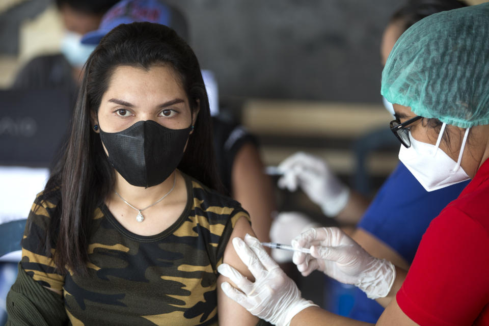 Health workers administer Moderna COVID-19 booster shots to residents during a third dose vaccination campaign in Denpasar, Bali, Indonesia Saturday, Jan. 29, 2022. (AP Photo/Firdia Lisnawati)