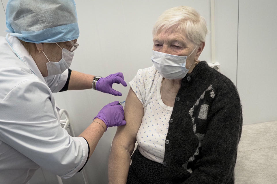 A Russian medical worker administers a shot of Russia's Sputnik V coronavirus vaccine to Galina Shilova in a local rural medical post in the village of Ikhala in Russia’s Karelia region, Tuesday, Feb. 16, 2021. “When you watch TV and see how people are suffering … you don’t want that. You want to live a little longer,” Shilova said. (AP Photo/Dmitri Lovetsky)