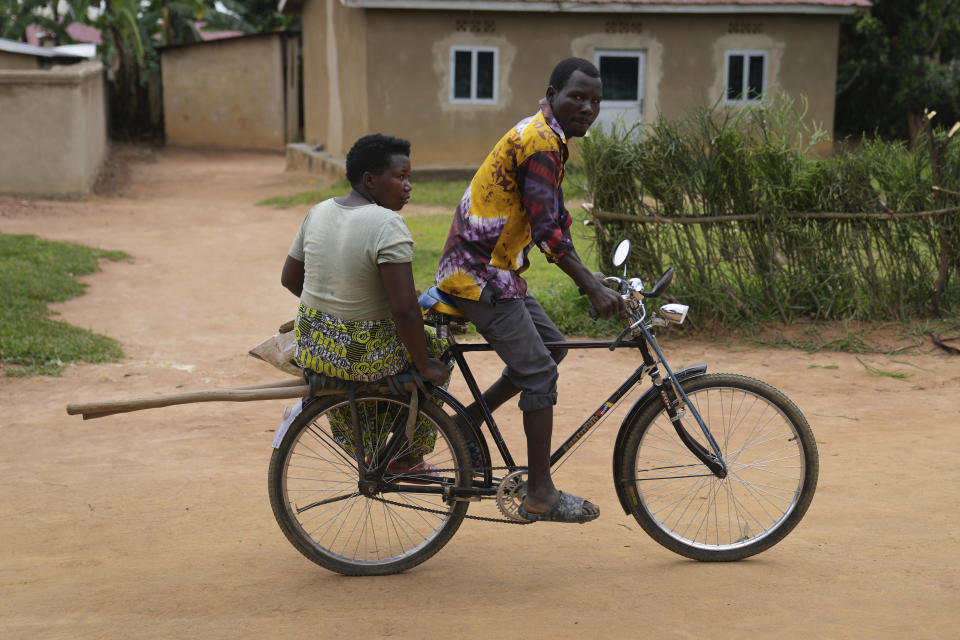 A Rwandan man transports his wife on a bicycle from a cropping field at Mybo reconciliation village, in Nyamata, Rwanda Friday, April 5, 2024. Rwanda on Sunday will commemorate the 30th anniversary of when the country descended into an orgy of violence in which some 800,000 Tutsis and moderate Hutus were massacred by the majority Hutu population over a 100-day period in what was the worst genocide in recent history. (AP Photo/Brian Inganga)