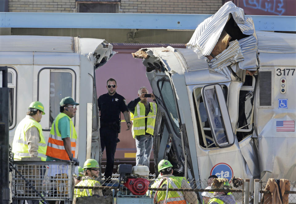 Authorities inspect the wreckage of two Chicago Transit Authority trains that crashed Monday, Sept. 30, 2013, in Forest Park, Ill. The crash happened when a westbound train stopped at the CTA Blue Line Harlem station, and was struck by an eastbound train on the same track. The CTA is investigating the cause of the crash, including why the trains were on the same track. A CTA official said 33 people suffered non-life threatening injuries. (M. Spencer Green/AP)