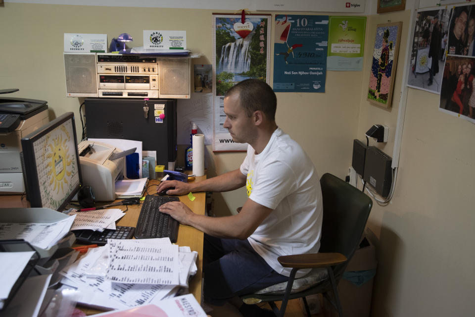 Igor Loparic enters information on prepared packages of aid for people in need for help in Pula, Croatia, Tuesday, May 26, 2020. As local businesses suffered under the coronavirus lockdown, even once well-off families have found themselves struggling and many have turned to the local "Our Dream Their Smile" group for help with food, other necessities or legal advice. (AP Photo/Darko Bandic)