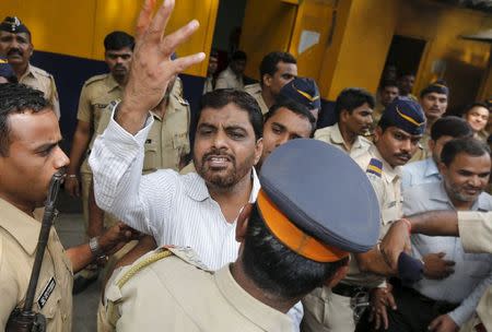 One of the 12 men, convicted of planning several blasts on crowded commuter trains in the financial capital of Mumbai in 2006, gestures to a relative (unseen) as he is escorted by police to a court in Mumbai, India, September 14, 2015. REUTERS/Shailesh Andrade