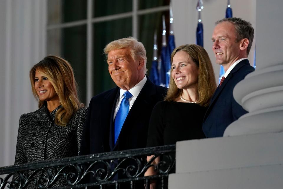 First lady Melania Trump, President Donald Trump, Amy Coney Barrett and Jesse Barrett stand on the Blue Room Balcony after Supreme Court Justice Clarence Thomas administered the constitutional oath on the South Lawn of the White House in Washington.