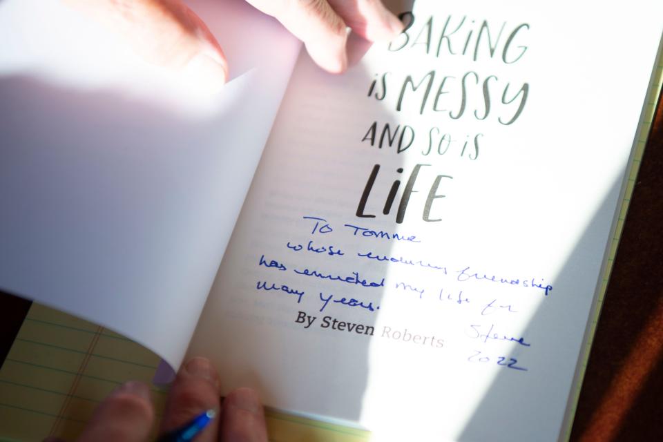 Steven Roberts, author of the book "Baking is Messy And So Is Life," signs a copy of his book at a book signing at Rami's Cafe in Knoxville, Tenn. on Wednesday, Aug. 24, 2022.