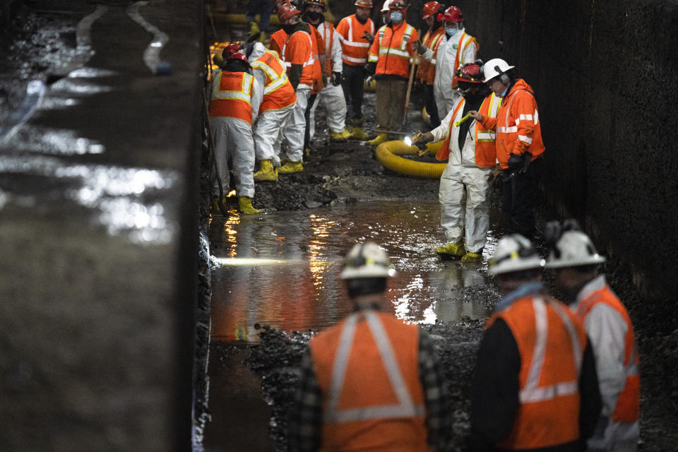 Amtrak workers perform tunnel repairs to a partially flooded train track bed, Saturday, March 20, 2021, in Weehawken, N.J. With a new rail tunnel into New York years away at best, Amtrak is embarking on an aggressive and expensive program to fix a 110-year-old tunnel in the interim. (AP Photo/John Minchillo)