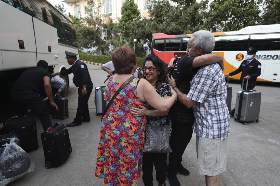 Passengers from the MS Westerdam, owned by Holland America Line, bid farewell before heading for the airport, in Phnom Penh, Cambodia, Wednesday, Feb. 19, 2020. Having finally reached a friendly port willing to accept them and stepped ashore after weeks of uncertainty at sea, some hundreds of the cruise ship passengers eyed warily over fears of a new virus are now finding a way home. (AP Photo/Heng Sinith)