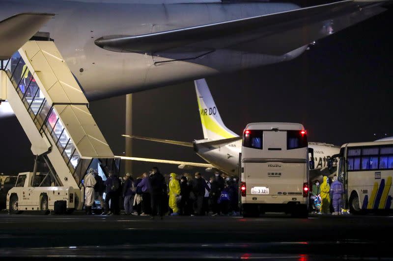 Passengers of the cruise ship Diamond Princess, where dozens of passengers were tested positive for coronavirus, board their plane at Haneda airport in Tokyo