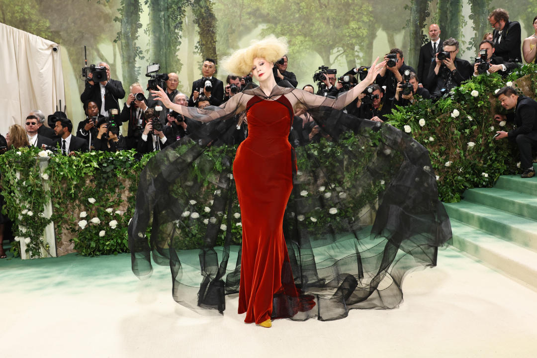 Gwendoline Christie, arms outstretched, poses for photographers.