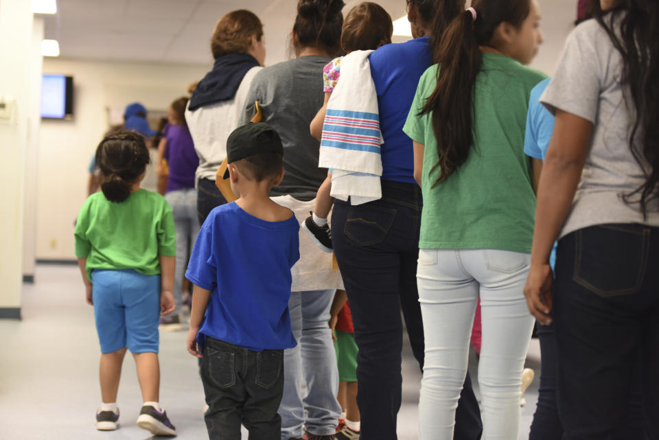 Mothers and their children stand in line at South Texas Family Residential Center 