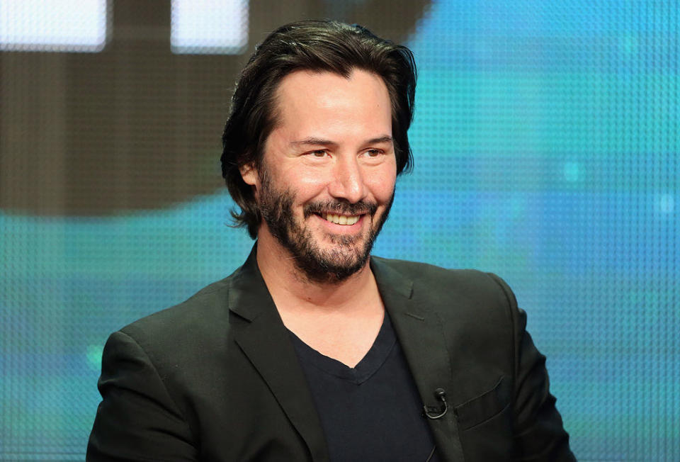 Keanu Reeves smiling during a panel