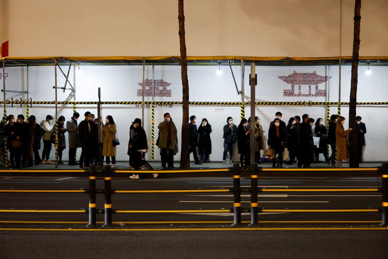 People wait for their bus at a bus stop amid the coronavirus disease (COVID-19) pandemic in Seoul