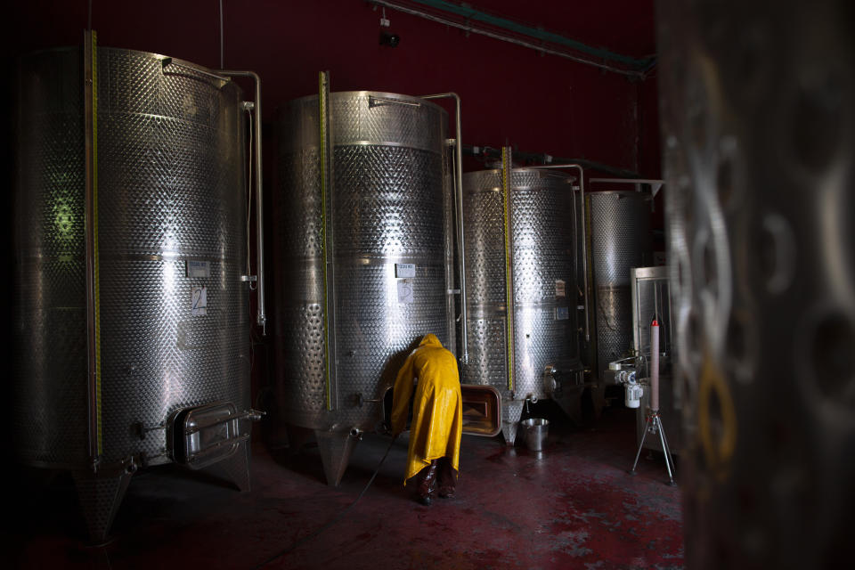 File- In this Tuesday, March 11, 2014 file photo, a worker cleans a container at Psagot winery in the West Bank Jewish settlement of Psagot. Secretary of State Mike Pompeo's expected tour of a winery in the occupied West Bank this week will be the first time a top U.S. diplomat has visited an Israeli settlement, a parting gift from an administration that has taken unprecedented steps to support Israel's claims to war-won territory. (AP Photo/Oded Balilty, File)