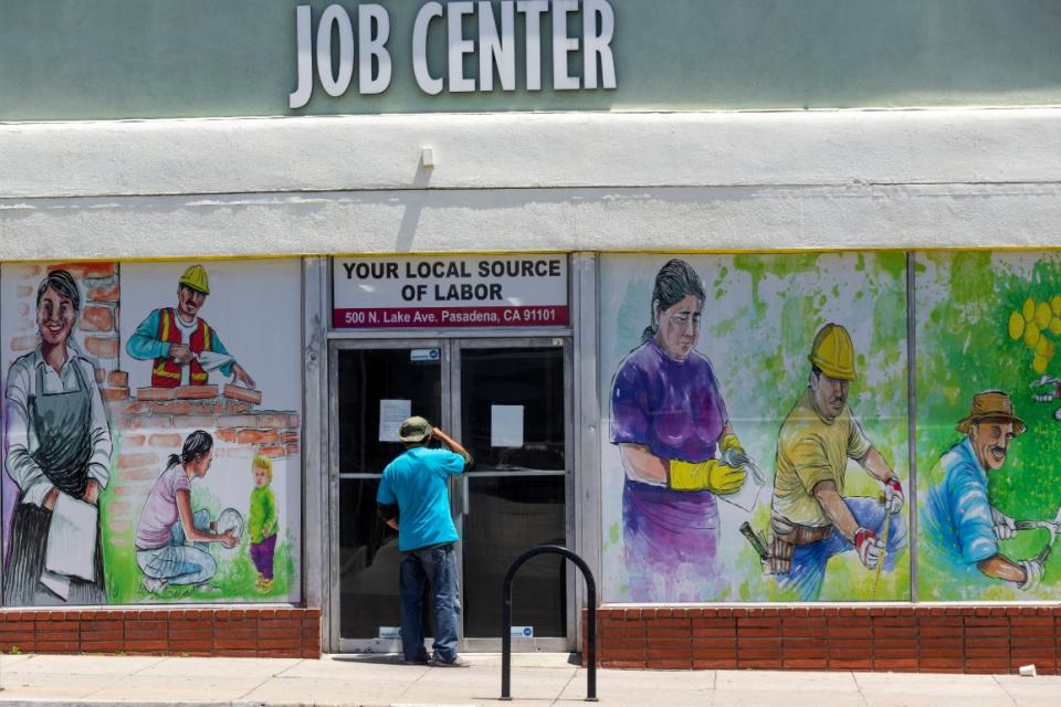 A person looks inside the closed doors of the Pasadena Community Job Center in Pasadena, Calif., during the coronavirus outbreak.