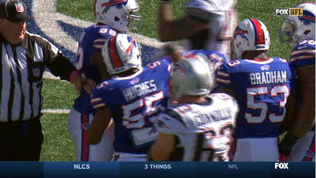 Buffalo Bills' Jerry Hughes gets his helmet stuck on teammate's jersey