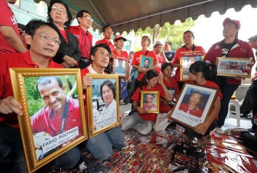 Anti-government "Red Shirts" protesters hold portraits of victims killed in the 2010 violence between government forces and protesters during a ceremony marking the first anniversary in Bangkok on April 10, 2011. Crowds of anti-government "Red Shirts" began to gather in Bangkok to mark a year since deadly clashes between troops and protesters during their mass rally in the capital