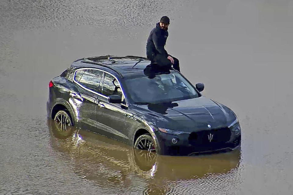 A man is stranded on his vehicle in floodwaters in Columbus, Ohio, on April 3, 2024.  (Ohio Department of Transportation via AP)