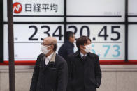 People walk by an electronic stock board of a securities firm in Tokyo, Monday, Jan. 27, 2020. Shares tumbled Monday in the few Asian markets open as China announced sharp increases in the number of people affected in an outbreak of a potentially deadly virus. (AP Photo/Koji Sasahara)