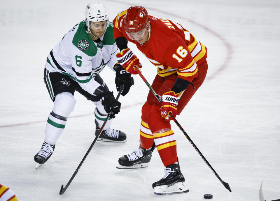 Dallas Stars defenceman Colin Miller, left, checks Calgary Flames defenseman Nikita Zadorov during the first period of an NHL hockey game Saturday, March 18. 2023, in Calgary, Alberta. (Jeff McIntosh/The Canadian Press via AP)