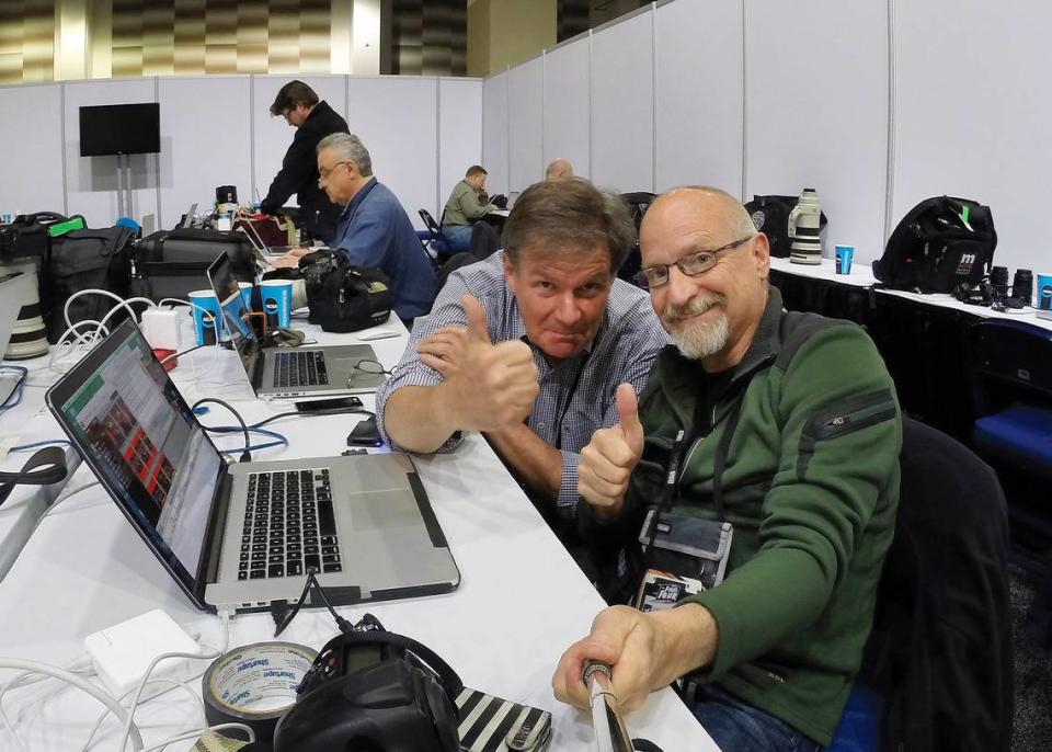 News & Observer photojournalist Robert Willett and Chuck Liddy (right) work from the press area at a college basketball tournament.