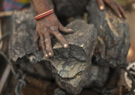 A local woman prepares to carry coal at an open coal field at Dhanbad district in Jharkhand September 19, 2012. REUTERS/Ahmad Masood