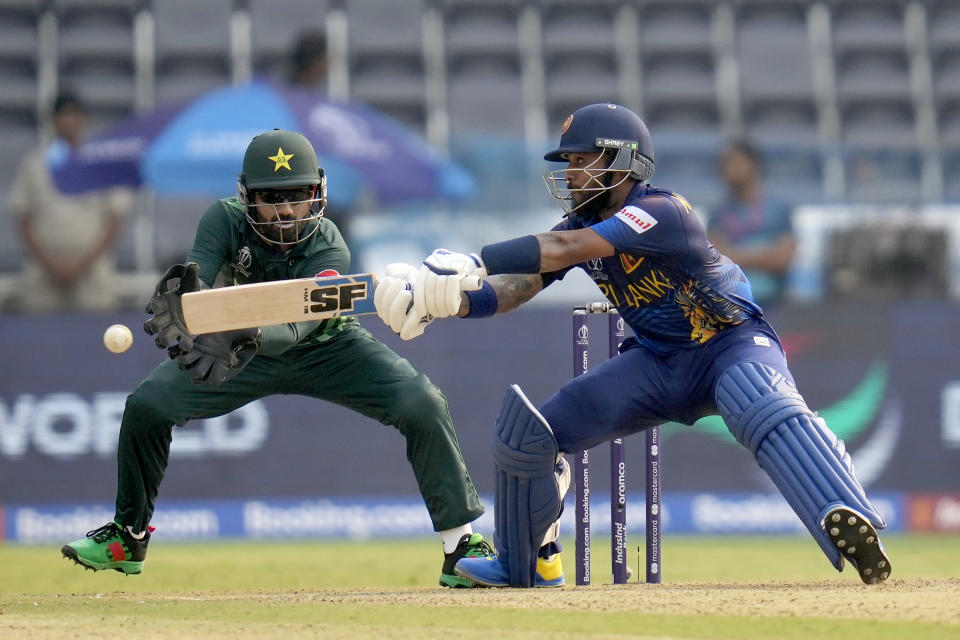 Sri Lanka's Kusal Mendis plays a shot as Pakistan's Mohammad Rizwan watches during the ICC Cricket World Cup match between Pakistan and Sri Lanka in Hyderabad, India, Tuesday, Oct. 10, 2023. (AP Photo/Rafiq Maqbool)