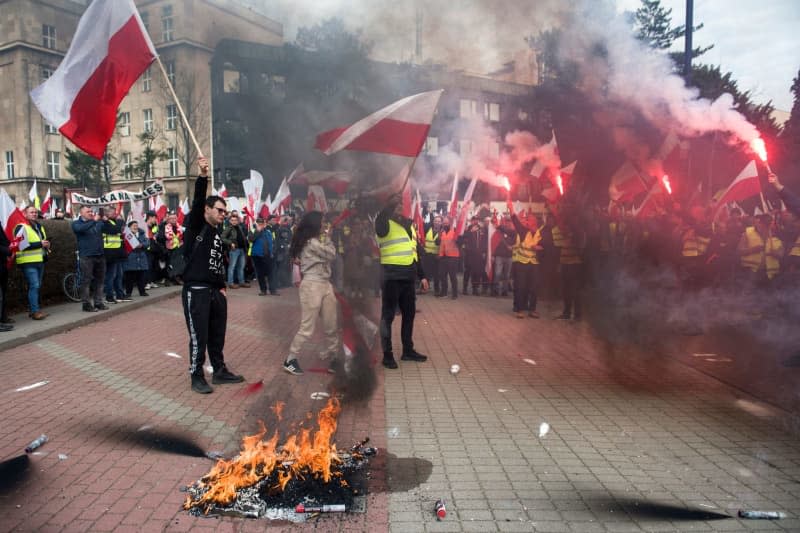 Rolnicy machają i palą polskie flagi podczas demonstracji w Warszawie przeciwko polityce rolnej UE.  Zdjęcia Attila Husejnow/SOPA za pośrednictwem ZUMA Press Wire/dpa