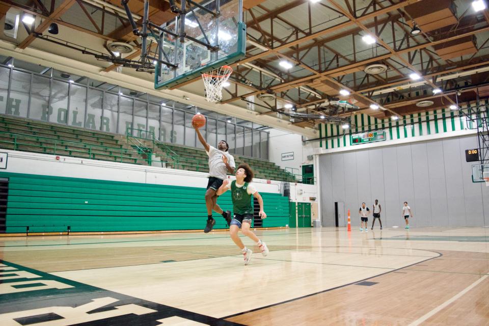 Amos Poe (left) reaches for a layup during a one-on-one drill against Des Moines North teammate Jadrian Naab.