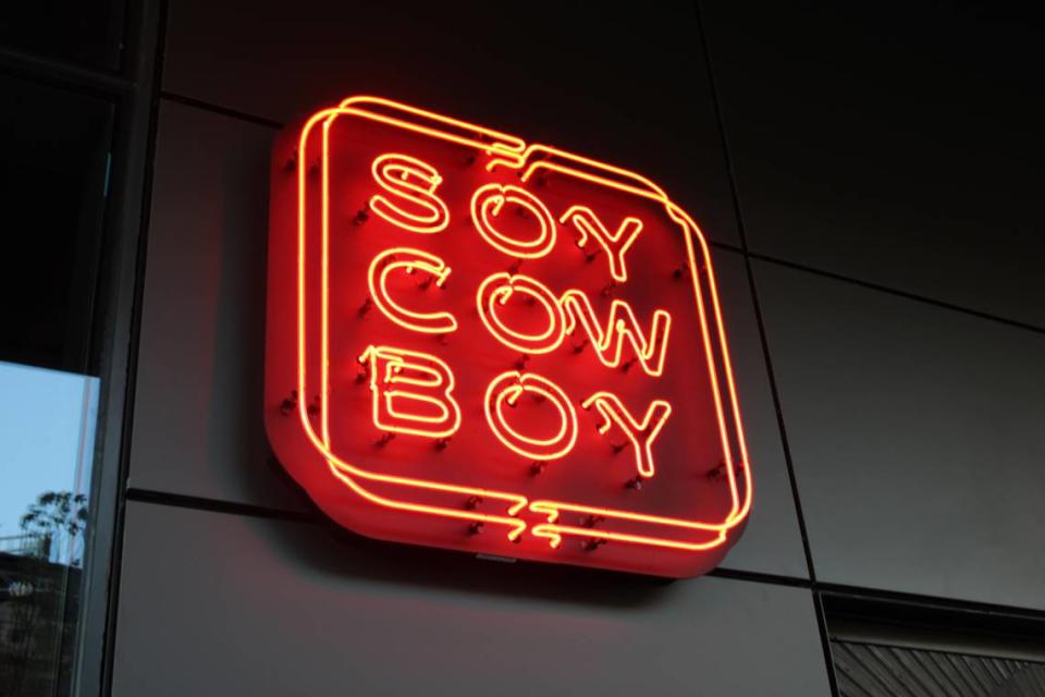 Soy Cowboy at Loews Hotel in Arlington has a neon sign entrance across the street from Choctaw Stadium, Globe Life Field, and AT&T Stadium