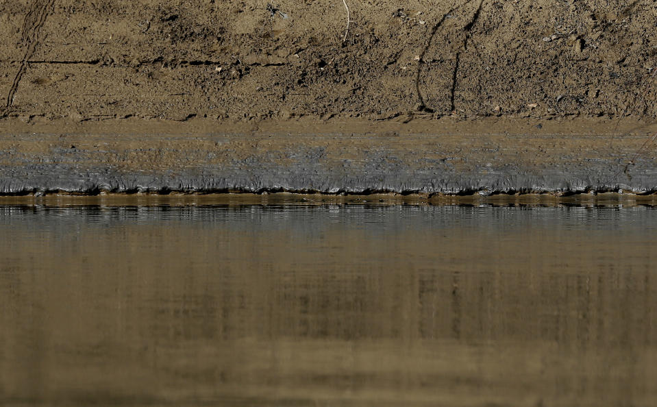 Coal ash lines the banks of the Dan River as state and federal environmental officials continued their investigations of a spill of coal ash into the river in Eden, N.C., Wednesday, Feb. 5, 2014. Duke Energy estimates that up to 82,000 tons of ash has been released from a break in a 48-inch storm water pipe at the Dan River Power Plant on Sunday. (AP Photo/Gerry Broome)