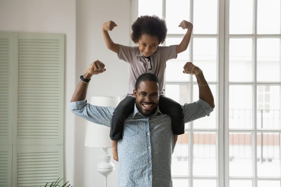 A parent and a child flexing their muscles.