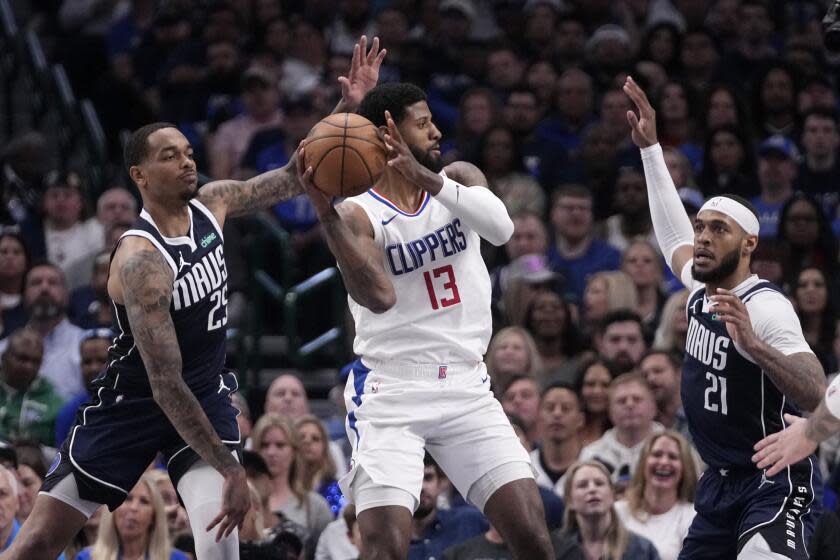 Los Angeles Clippers' Paul George (13) looks to pass the ball as Los Angeles Clippers' Moussa Diabate (25) and Kobe Brown (21) defend during the second half of Game 2 of an NBA basketball first-round playoff series in Dallas, Friday, April 26, 2024. (AP Photo/Tony Gutierrez)