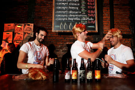 Bartenders fix their wigs as they impersonate Republican presidential nominee Donald Trump during a Mexican brewery booze-up in Mexico City, Mexico October 20, 2016. REUTERS/Carlos Jasso