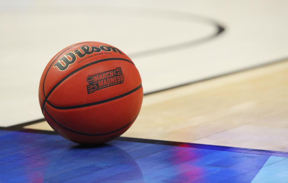 FILE -- In this March 18, 2017, file photo, an official game ball with the March Madness logo sits in the court during a second-round men's college basketball game between Villanova and Wisconsin in the NCAA Tournament in Buffalo, N.Y. Coaches did the best they could to prepare for the big moment, yet still find themselves in a scramble once it actually happened. The NCAA announced last month that the season would begin on Nov. 25 and teams are still trying to fill all the holes in their schedules. (AP Photo/Bill Wippert, File)