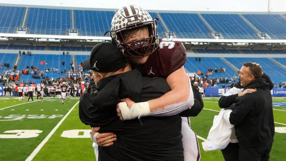 Pikeville running back Brenden Anthony, left, and head coach Chris McNamee, right, celebrate after the Panthers won their third state championship in a row.