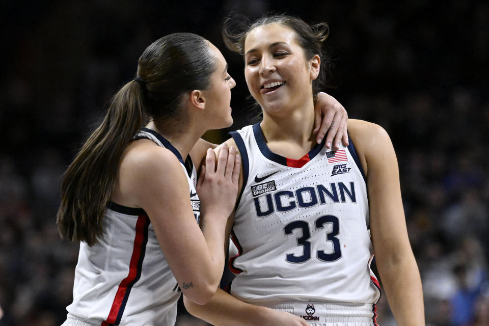 UConn's Nika Muhl, left, congratulates Caroline Ducharme (33), who made the go-ahead basket in the final seconds of the team's NCAA college basketball game against Creighton, Wednesday, Feb. 15, 2023, in Storrs, Conn. (AP Photo/Jessica Hill)