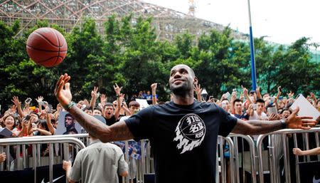 NBA basketball player LeBron James of Cleveland Cavaliers plays with a basketball during a promotional event at a store in Guangzhou, Guangdong province, July 22, 2014. REUTERS/Alex Lee