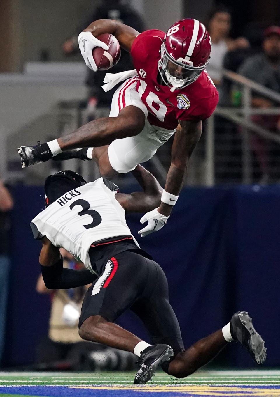 Alabama tight end Jahleel Billingsley (19) tries to hurdle Cincinnati safety Ja'von Hicks (3) in the 2021 College Football Playoff Semifinal game at the 86th Cotton Bowl in AT&T Stadium in Arlington, Texas Friday, Dec. 31, 2021. [Staff Photo/Gary Cosby Jr.]