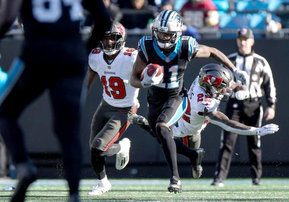 Carolina Panthers wide receiver Ihmir Smith-Marsette, center, avoids a tackle by Tampa Bay Buccaneers running back Chase Edmonds at the Bank of America Stadium in Charlotte, N.C., on Sunday, January 7, 2024.