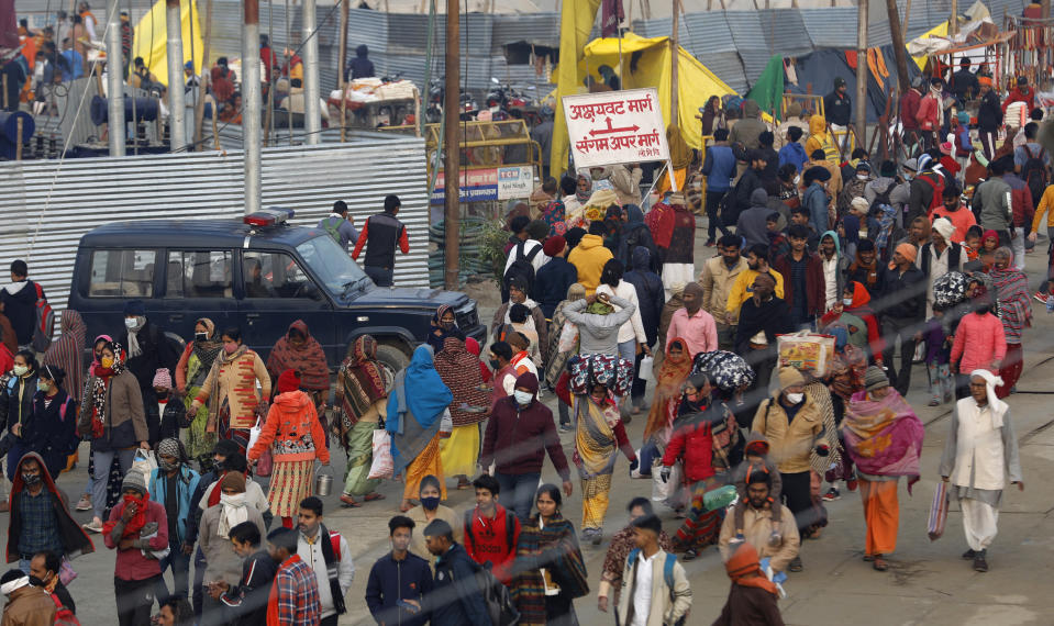 Hindu devotees crowd the Sangam, the confluence of three rivers — the Ganges, the Yamuna and the mythical Saraswati, to take a ritualistic bath during Makar Sankranti festival that falls during the annual traditional fair of Magh Mela festival, one of the most sacred pilgrimages in Hinduism, in Prayagraj, India. Friday, Jan. 14, 2022. Tens of thousands of devout Hindus, led by heads of monasteries and ash-smeared ascetics, took a holy dip into the frigid waters on Friday despite rising COVID-19 infections in the country. (AP Photo/Rajesh Kumar Singh)