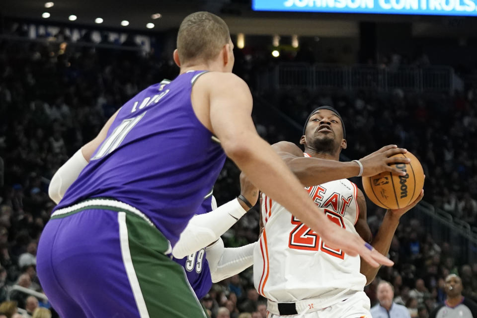 Miami Heat's Jimmy Butler, right, drives to the basket against Milwaukee Bucks' Jae Crowder and Brook Lopez, foreground, during the first half of an NBA basketball game Friday, Feb. 24, 2023, in Milwaukee. (AP Photo/Aaron Gash)