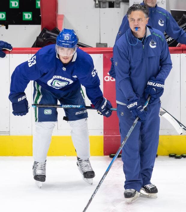 Vancouver Canucks captain Bo Horvat, left, stands beside head coach Travis Green. Both contracted COVID-19 in the outbreak that hit the team.  (Darryl Dyck/The Canadian Press - image credit)