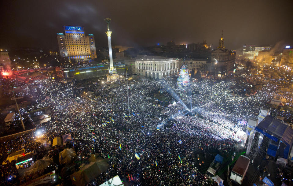 FILE - In this Jan. 1, 2014, file photo Pro-European Union activists hold lights as they sing the Ukrainian national anthem, celebrating the New Year in Kyiv's main square. At least 100,000 Ukrainians gathered in a sign of support for integration with Europe. On Nov. 21, 2023, Ukraine marks the 10th anniversary of the uprising that eventually led to the ouster of the country’s Moscow-friendly president. (AP Photo/Efrem Lukatsky, file)