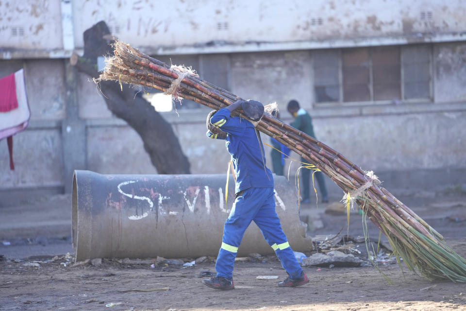 A man carries a bunch of sugar cane for sale on the streets of Harare, Zimbabwe, Monday, May, 23, 2022. Rampant inflation is making it increasingly difficult for people in Zimbabwe to make ends meet. Since the start of Russia’s war in Ukraine, official statistics show that Zimbabwe’s inflation rate has shot up from 66% to more than 130%. The country's finance minister says the impact of the Ukraine war is heaping problems on the already fragile economy. (AP Photo/Tsvangirayi Mukwazhi)