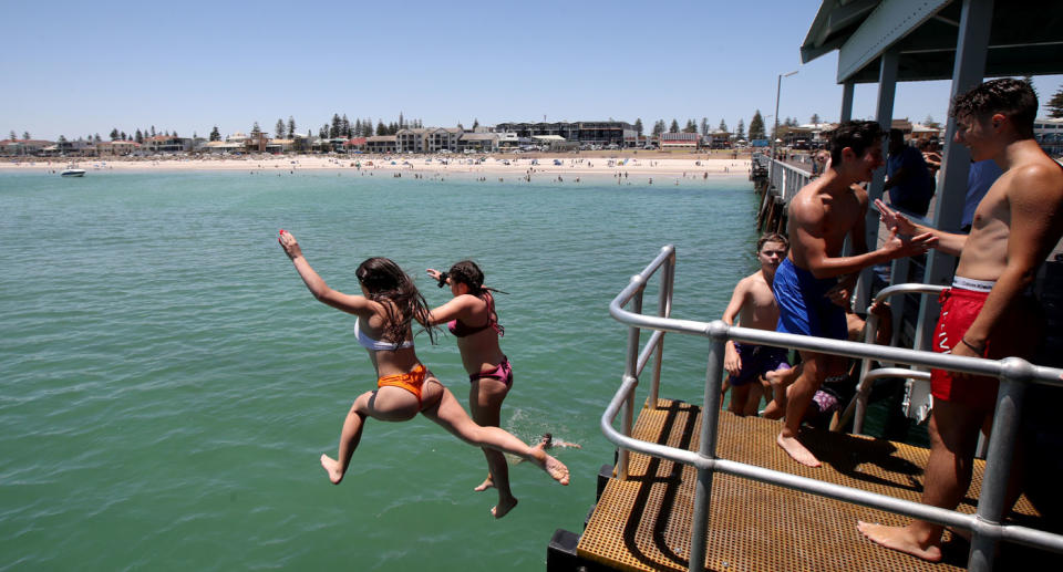 Swimmers dive from the Henley Beach jetty in Adelaide. Source: AAP