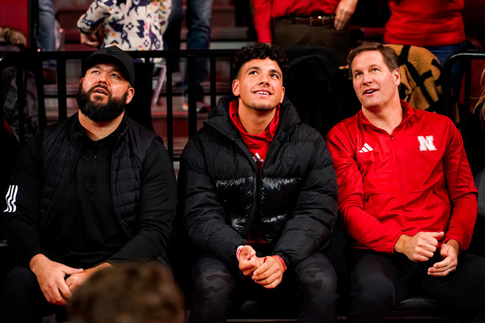 Jan. 3, 2024; Lincoln, Nebraska; Nebraska Cornhuskers football assistant coach Donovan Raiola (left), Dylan Raiola (center) and athletic director Trev Alberts sit courtside before the game against the Indiana Hoosiers at Pinnacle Bank Arena. Dylan is the top quarterback recruit in the 2024 class. Dylan Widger-USA TODAY Sports